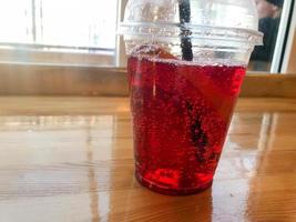 Delicious sweet raspberry strawberry cherry lemonade natural with syrup and gas bubbles in a plastic disposable cup with a straw. Fast food, drink photo