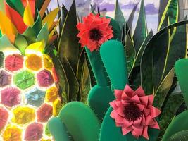 Abstract plastic artificial green shiny glowing cheerful beautiful joyful Mexican cacti with flowers. The background photo