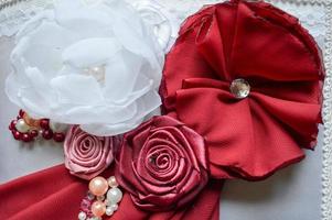 Red and white homemade flowers from a beautiful fabric decorated with rhinestones, pearls and beads. photo