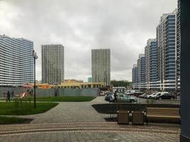 urban landscape. Tall blue and white glass apartment buildings stand in the city center. there is a beige shopping center in the center. modern residential building, city architecture photo