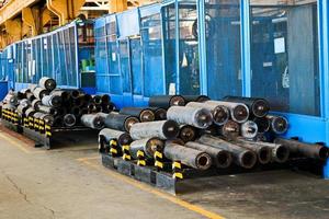 Warehouse, storage of iron rollers, pipes, spare parts at an industrial plant photo