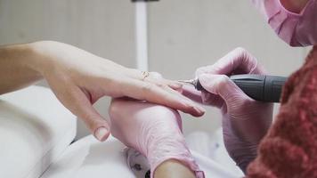 nail care. Girl doing manicure. Beauty salon. In the pink medical gloves. Close up. video