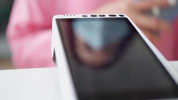 Close-up, an unrecognizable woman in a pink shirt pays for a purchase using a mobile phone by bank transfer. Contactless payment. video