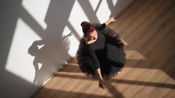 Beautiful Ballerina in a Black Tutu and Pointe Shoes Gracefully Dances against a White Wall in Bright Sunlight. Slow Motion. Top view video