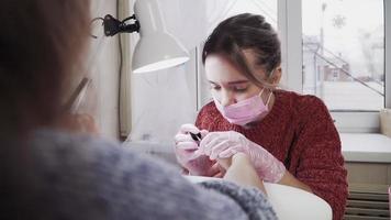 garota fazendo manicure para um cliente no salão de beleza. video