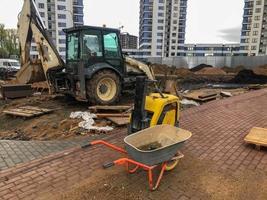 trolley for transporting heavy materials, concrete, bricks and sand. next to the machine for the manufacture of road surface. and a tractor for transporting sand, digging holes. construction new area photo