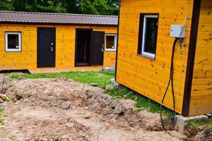 Construction of small yellow wooden frame prefabricated pre-fabricated eco-house of suburban modular fast-growing houses, buildings, cottages. Industrial builde photo