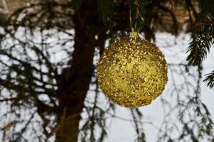 hermosas bolas amarillas, doradas y festivas, adornos navideños para el nuevo año, navidad colgando de ramas de abeto contra el fondo de la nieve blanca en invierno foto