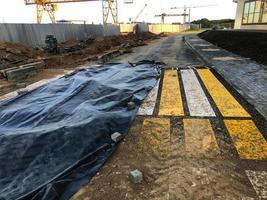 pedestrian markings on the road. creating a pattern on the asphalt. the markings are covered with black foil to prevent contamination. preparation for the delivery of new houses for human life photo