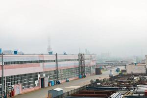 paisaje industrial. vista panorámica de las tuberías tecnológicas. tuberías oxidadas, rubíes azules, comunicaciones de producción. reparar edificios en producción. contra el fondo de un cielo brumoso foto