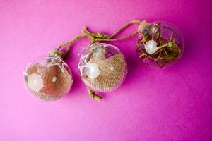 Three small round glass transparent vintage improvised elegant hipster decorative beautiful festive New Year's balls, Christmas decorations with hay, straw inside and with a star photo