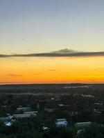 morning at dawn. panorama from the window. a greenhouse made of polyethylene, small houses made of wood, fertile areas, a vegetable garden. household. triangular slate roofs are on the houses photo