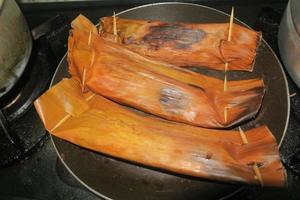 fish and spices wrapped in banana leaves called it pepes photo