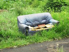 broken sofa thrown in the garden photo