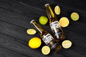 KHARKOV, UKRAINE - DECEMBER 9, 2020 Bottles of Corona Extra Beer with lime slices. Corona produced by Grupo Modelo with Anheuser Busch InBev most popular imported beer in the US photo