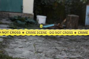 Crime scene tape for covering the area cordon. Yellow tape with blurred forensic law enforcement background in cinematic tone photo