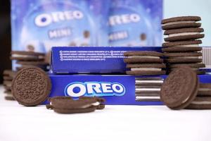 KHARKIV, UKRAINE - MAY 02, 2021 Oreo sandwich cookies and blue product boxes on white table. Oreo is a sandwich cookie with a sweet cream is the best selling cookie in the US photo