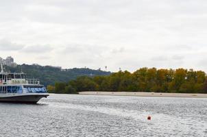 el barco navega a lo largo del río dniéper. otoño. mediodía. foto