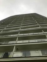 un hermoso edificio residencial alto y blanco con una arquitectura inusual. la casa tiene terrazas para pasear en verano y pasar tiempo al aire libre. contra el fondo del cielo oscuro foto