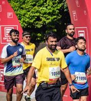 nueva delhi, india - 16 de octubre de 2022 - carrera de media maratón de vedanta delhi después de covid en la que los participantes del maratón están a punto de cruzar la línea de meta, media maratón de delhi 2022 foto