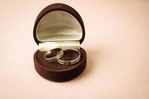 una hermosa caja de regalo festiva roja terciopelo para dos compromisos, anillos de boda con preciosos anillos redondos de oro preciosos. concepto propuesta de matrimonio, boda, compromiso foto