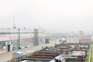 Industrial landscape. Panoramic view of the technological pipes. Rusty pipes, blue rubies, production communications. Repair buildings in production. Against the background of a misty sky photo