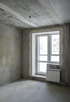 Unfinished building. Rough finish of the apartment. Room with plastered concrete walls. photo
