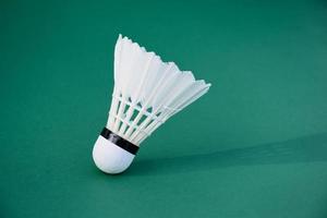 Cream white badminton shuttlecock and racket on floor in indoor badminton court, copy space, soft and selective focus on shuttlecocks. photo