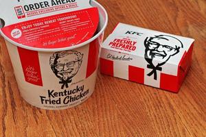 Washington USA  June 01 2022  American style fried chicken Kentucky Fly Chicken or KFC put in a bucket and put in a box to take home. KFC fried chicken in a package, a bucket photo