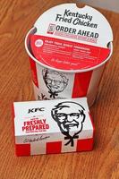 Washington USA  June 01 2022  American style fried chicken Kentucky Fly Chicken or KFC put in a bucket and put in a box to take home. KFC fried chicken in a package, a bucket photo