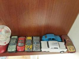 Row of children's car models on a shelf photo