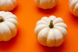 Halloween flat lay composition of black paper bats fand pumpkins on orange background. Halloween concept. photo