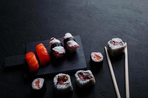 comida japonesa de sushi. maki ands rolls con atún, salmón, camarones, cangrejo y aguacate. vista superior de sushi variado. foto