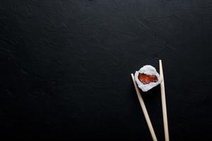 sushi con atún, salmón, arroz y palillos en un fondo aislado foto