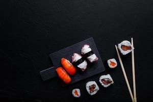 comida japonesa de sushi. maki ands rolls con atún, salmón, camarones, cangrejo y aguacate. vista superior de sushi variado. foto