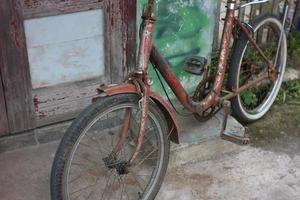 vieja bicicleta apoyada en un viejo cobertizo. foto