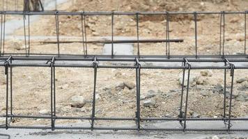 Wires for house beam structures. Place it on a cement-filled floor with black surrounds. Construction of the foundation of the house on the ground during the day time. photo