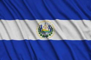 El Salvador flag  is depicted on a sports cloth fabric with many folds. Sport team banner photo