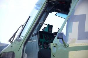 Helicopter cabin fragment close up. Camouflage aircraft fuselage and bulletproof glass photo