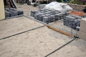 Rows of gray and dark grey walkway slab lying outdoors. Material for Paving Slabs by mosaic in progress. Cobblestone installation photo