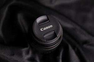 KHARKOV, UKRAINE - JANUARY 21, 2021 Canon EF 85mm 1.8 lens on fabric background. Detailed photo of Canon brand product