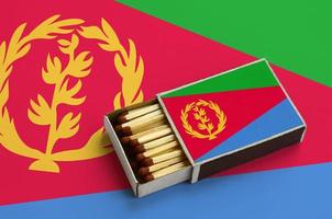 Eritrea flag  is shown in an open matchbox, which is filled with matches and lies on a large flag photo