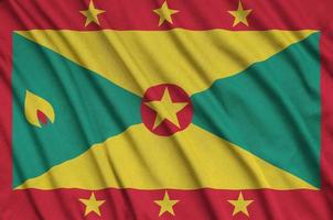 Grenada flag  is depicted on a sports cloth fabric with many folds. Sport team banner photo