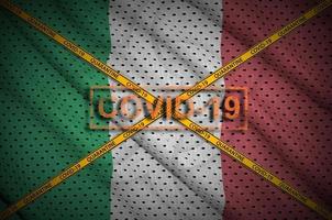 Italy flag and Covid-19 stamp with orange quarantine border tape cross. Coronavirus or 2019-nCov virus concept photo