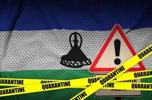 Lesotho flag and Covid-19 quarantine yellow tape. Coronavirus or 2019-nCov virus photo