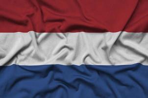 Netherlands flag  is depicted on a sports cloth fabric with many folds. Sport team banner photo