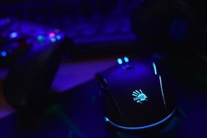 KHARKIV, UKRAINE - MAY 2, 2021 Gamesir g3s video game controller and Bloody p93 gaming mouse on office table with a4tech keyboard and headphones photo