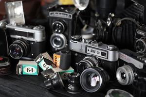 KHARKOV, UKRAINE - APRIL 27, 2021 Film photo cameras and another old retro photo equipment on black wooden table in photographer darkroom. Photographic gear from soviet union