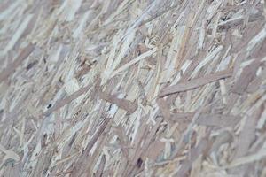 OSB boards made of brown wood chips sanded into a wooden background. Top view of OSB wood veneer background surface photo