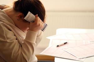 A sad young girl suffers from a loss after looking the unlucky result of the lottery gambling. The concept of losing the lottery and spend money photo